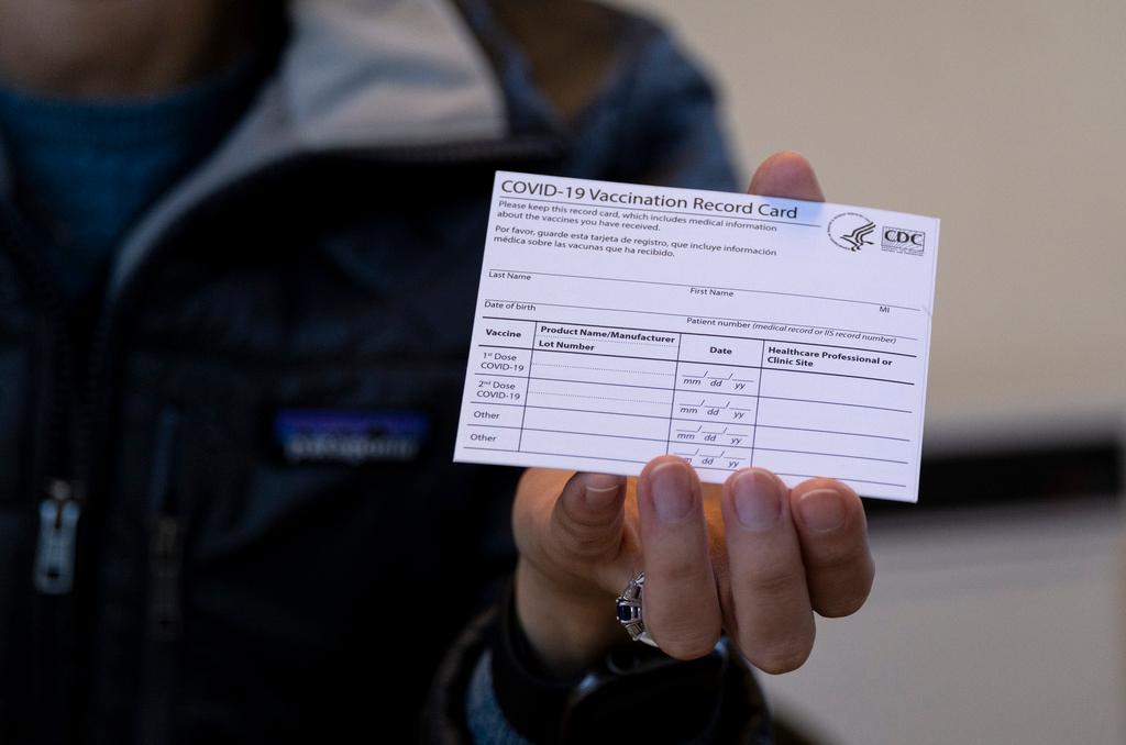 Person holding a COVID-19 vaccine card