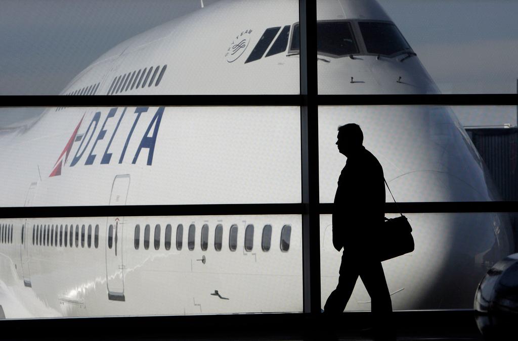 Passenger walks past a Delta Airlines 747 aircraft