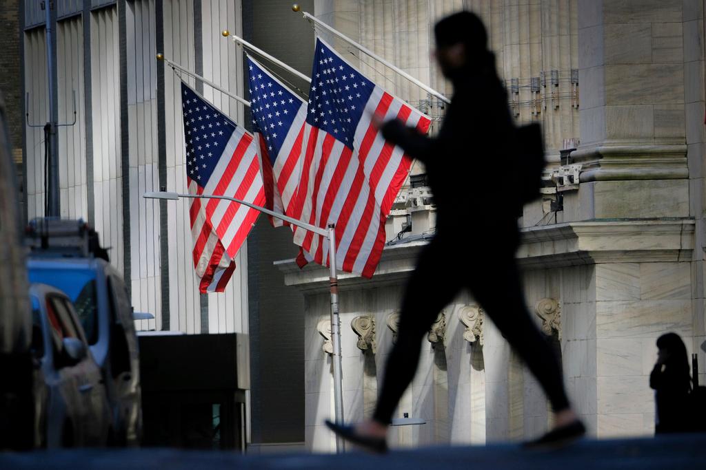 Person walks past New York Stock Exchange in New York City