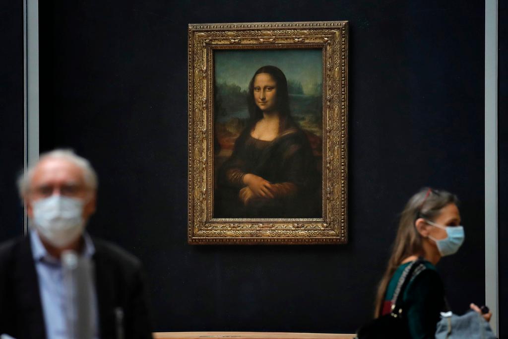 Journalists walk past Leonardo da Vinci's Mona Lisa during a visit of the Louvre museum Tuesday, June 23, 2020.