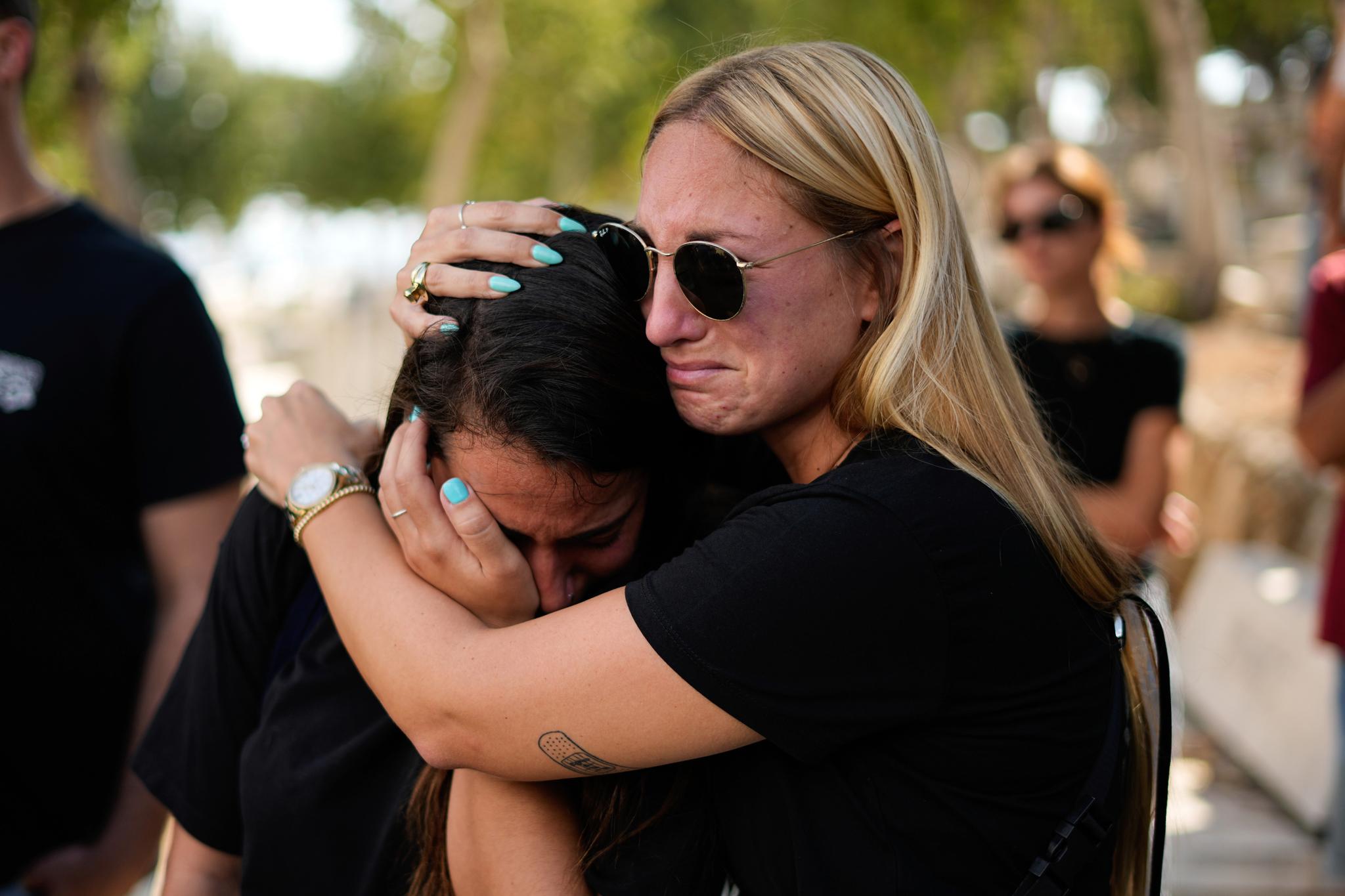 Two women crying and hugging each other.