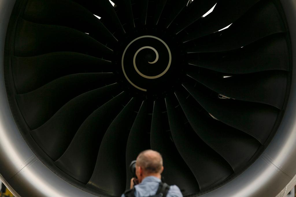 A visitor takes a photo of the Rolls-Royce jet engine of the Airbus A350-1000 parked at the static display area during the Singapore Airshow on Feb. 7, 2018