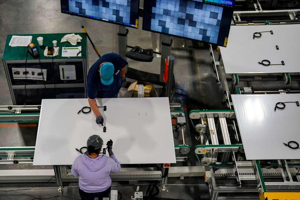 Employees work on residential solar panels inside the Hanwha Qcells Solar plant, Monday, Oct. 16, 2023, in Dalton, Ga.