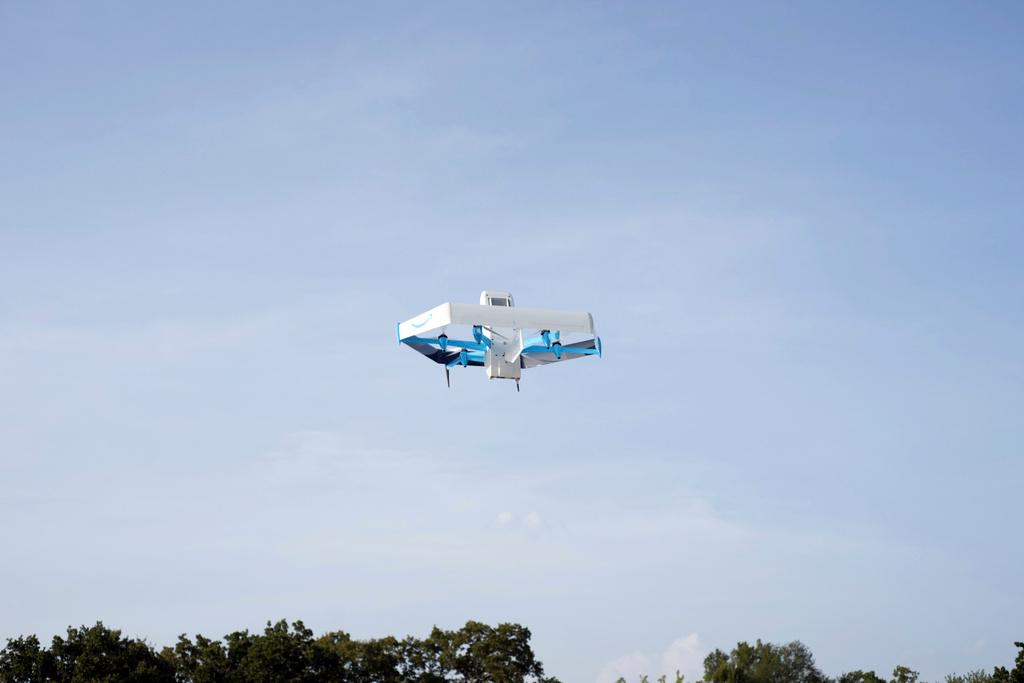This photo provided by Amazon shows a drone delivering presciption drugs in College Station, Texas.