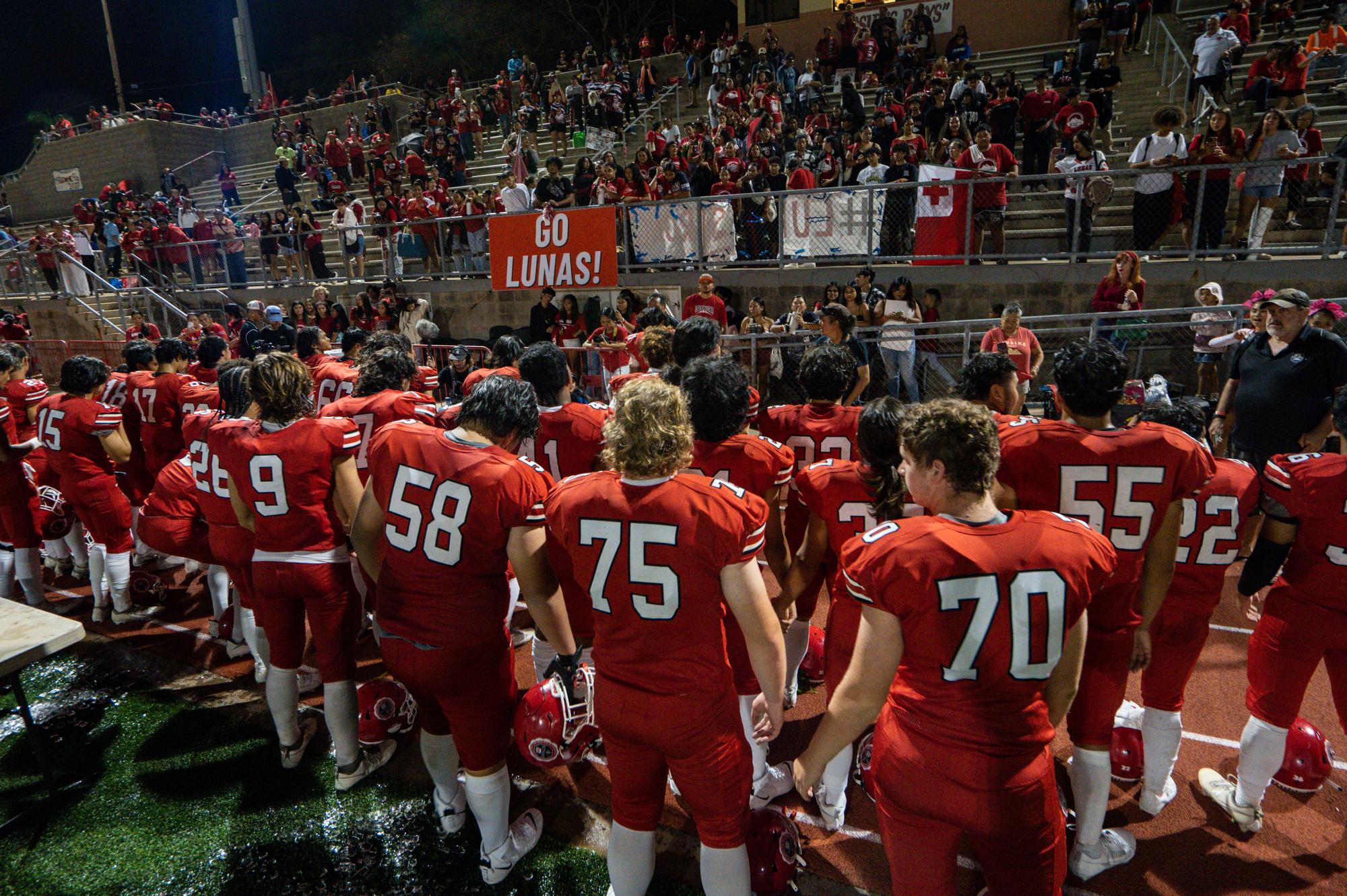 The Lahainaluna High School football team hold hands to thank the fans after a game at Sue D. Cooley Stadium, Saturday, Oct. 21, 2023, in Lahaina, Hawaii.