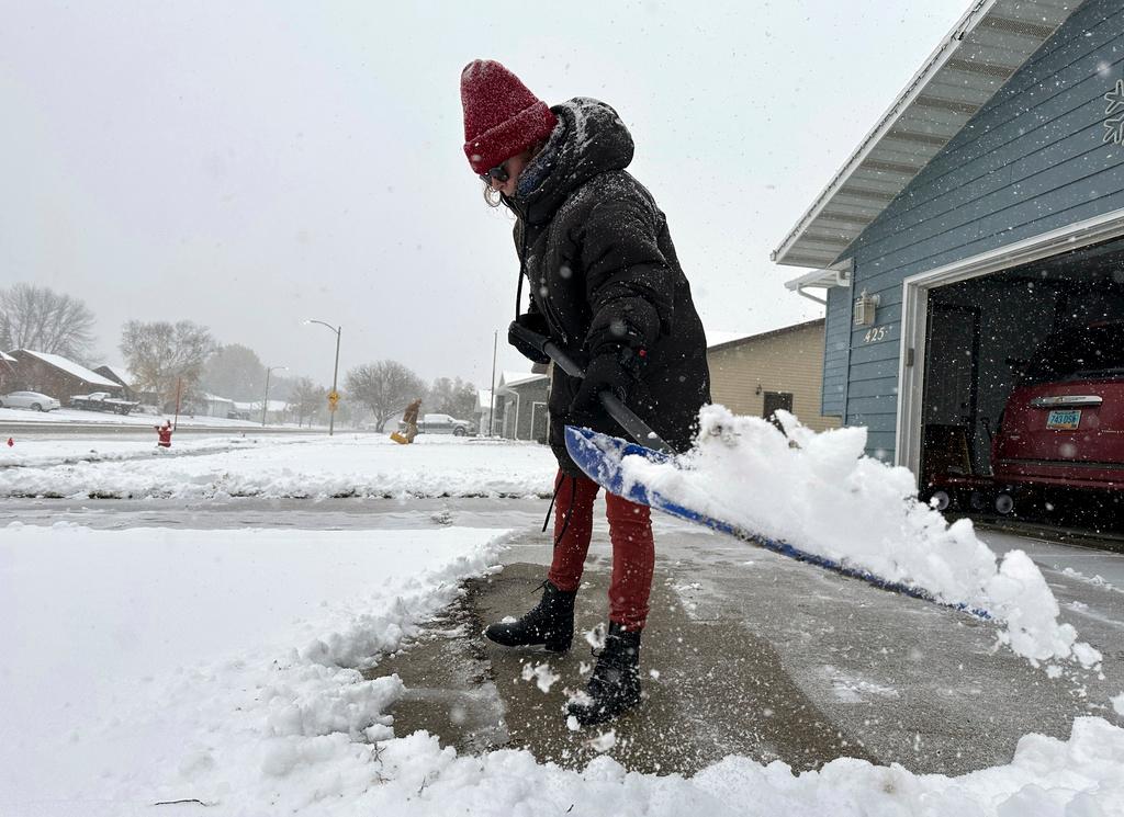 Laura Davenport shovels snow, Thursday, Oct. 26, 2023, in Bismarck, N.D. The snowstorm moving east from the northern Rockies dumped nearly a foot of snow in places in northwestern North Dakota after moving into the state on Wednesday, with more snow expected later on Thursday for southwestern and central North Dakota. As much as 11 inches of snow fell near Stanley in northwestern North Dakota, according to the National Weather Service. 