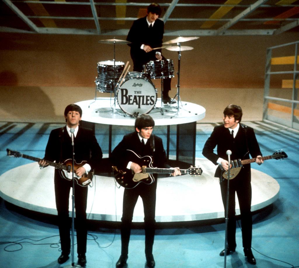 The Beatles, foreground from left, Paul McCartney, George Harrison, John Lennon and Ringo Starr on drums perform on the CBS "Ed Sullivan Show" in New York on Feb. 9, 1964