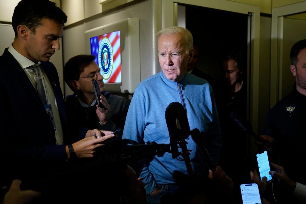 President Joe Biden talks to reporters aboard Air Force One 