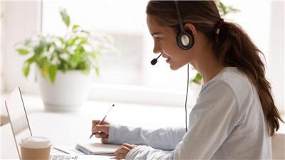 Woman with headset working on laptop
