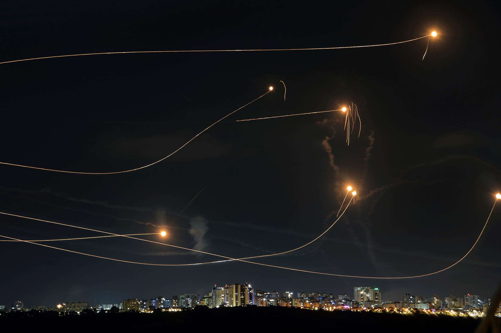 Long exposure shot of Iron Dome missiles intercepting rockets