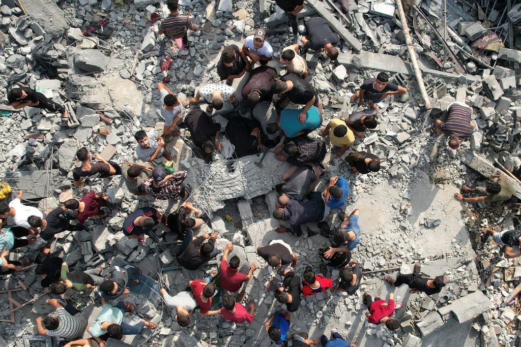 Palestinians look for survivors of the Israeli bombardment in the Maghazi refugee camp in the Gaza Strip 