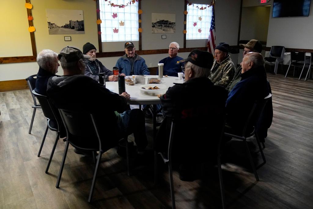 Earl Meyer, middle left, who fought for the U.S. Army in the Korean War, talks with fellow veterans at the American Legion