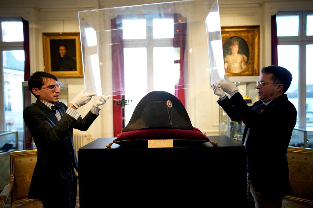 Raphael Pitchal, left, and Jean Christophe Chataignier of Osenat's auction house remove the protection of one of the signature broad, black hats that Napoléon wore when he ruled 19th century France and waged war in Europe at Osenat's auction house in Fontainebleau, south of Paris, Friday, Nov. 17, 2023.