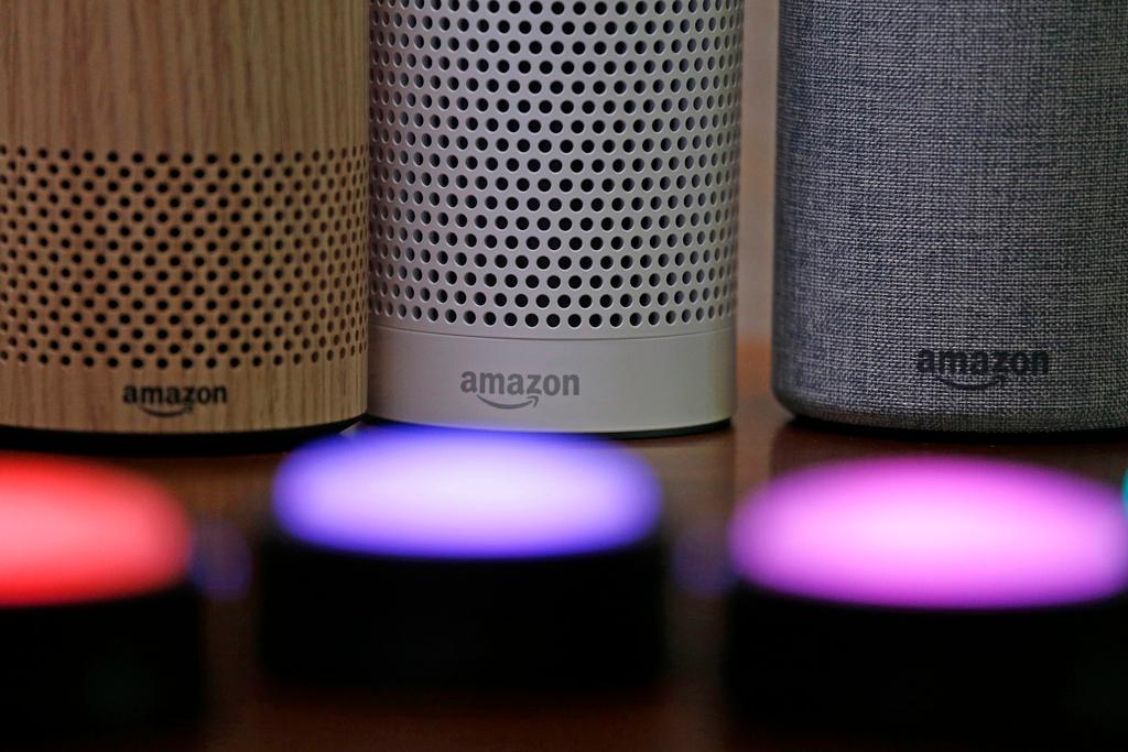 Amazon Echo and Echo Plus devices, behind, sit near illuminated Echo Button devices 