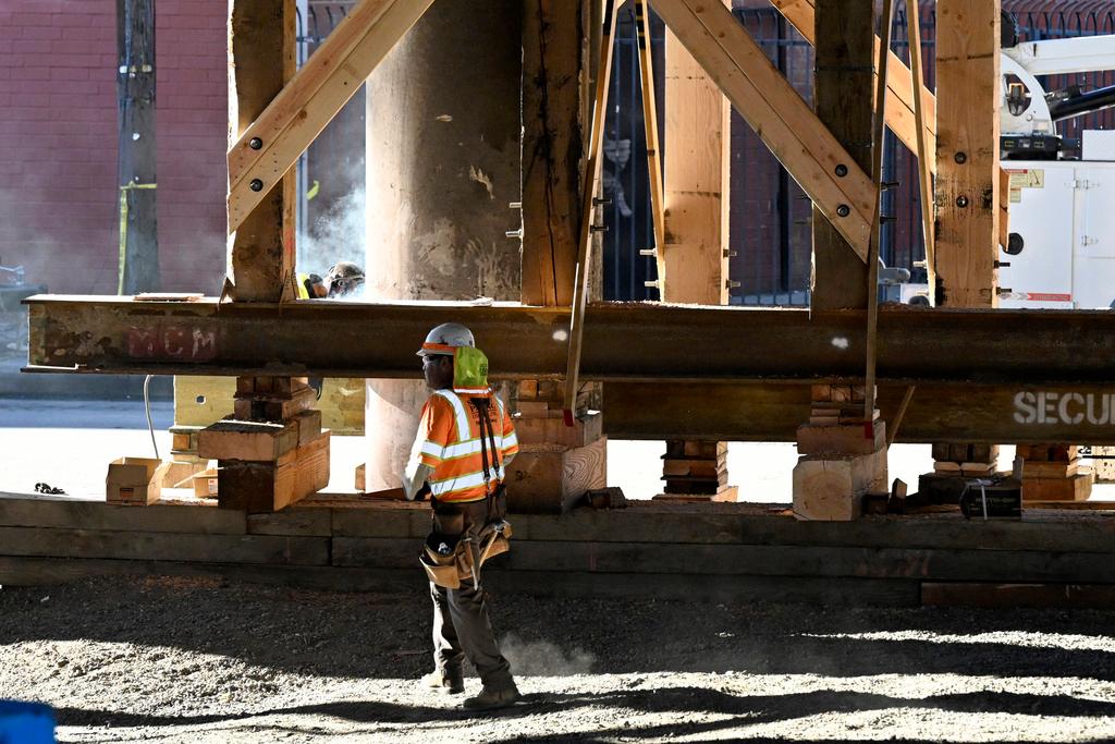 Construction workers work on the I-10 underpass, which was closed by an underpass fire on Saturday, Nov. 11, 2023, in Los Angeles, Sunday, Nov. 19. 