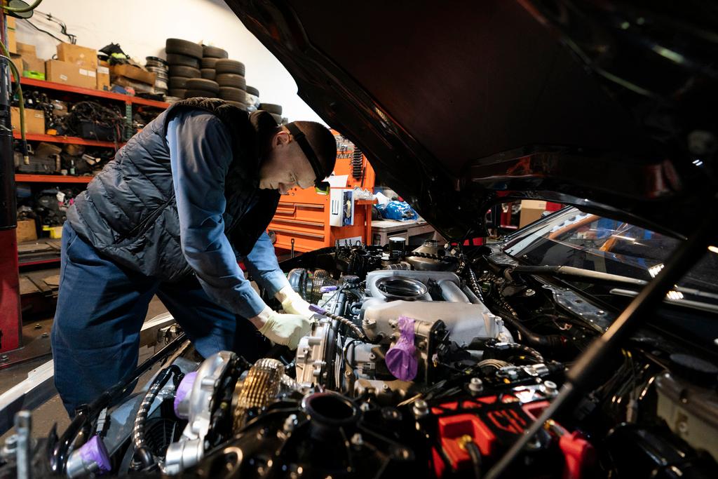 Mechanic David Stoliaruk works on the engine of a car at IC Auto in Philadelphia, May 2, 2023.