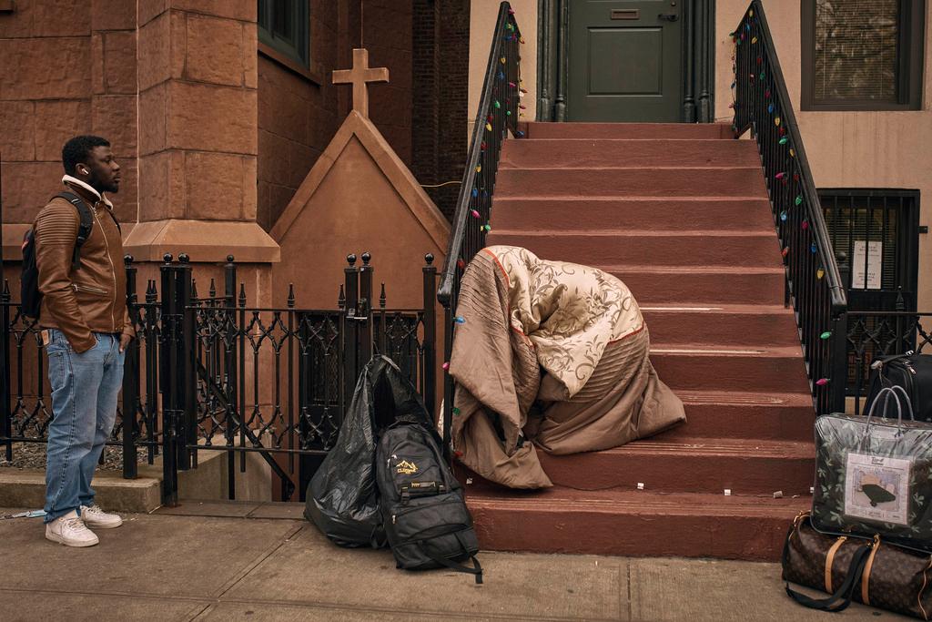 Migrants queue in the cold as they look for a shelter outside a migrant assistance center at St. Brigid Elementary School in NYC