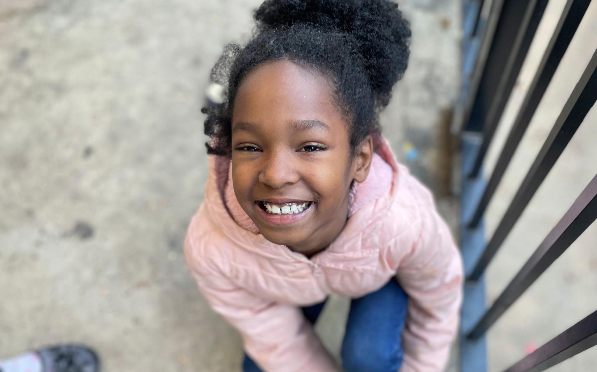 Little girl in pink jacket smiling for the camera