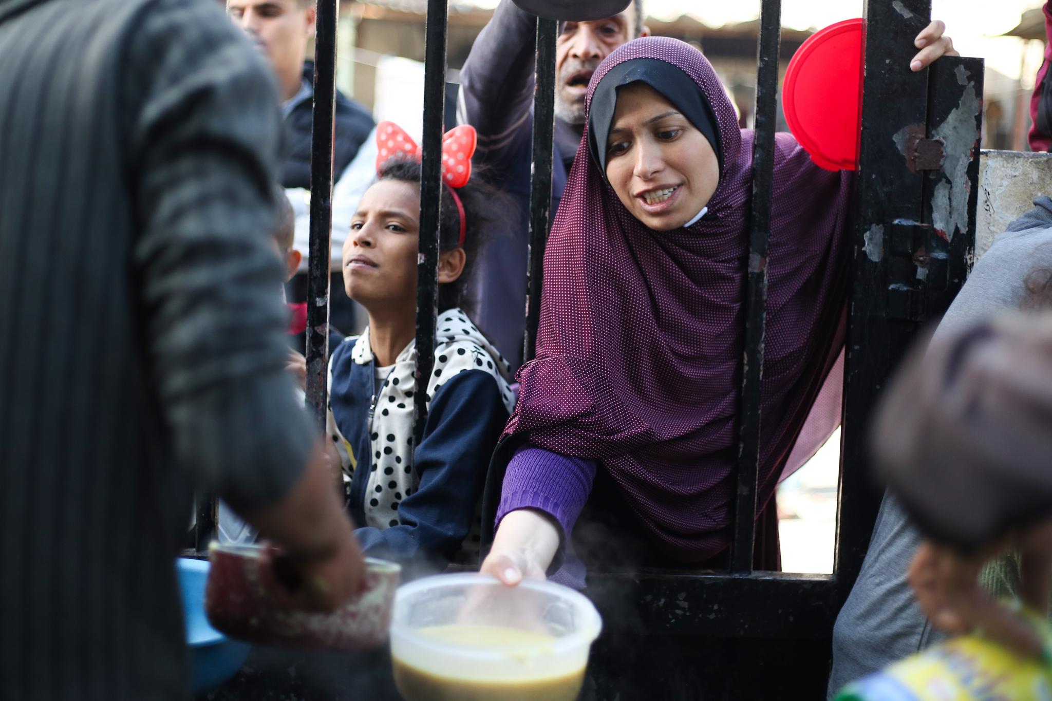 Woman and young girl lined up to get food