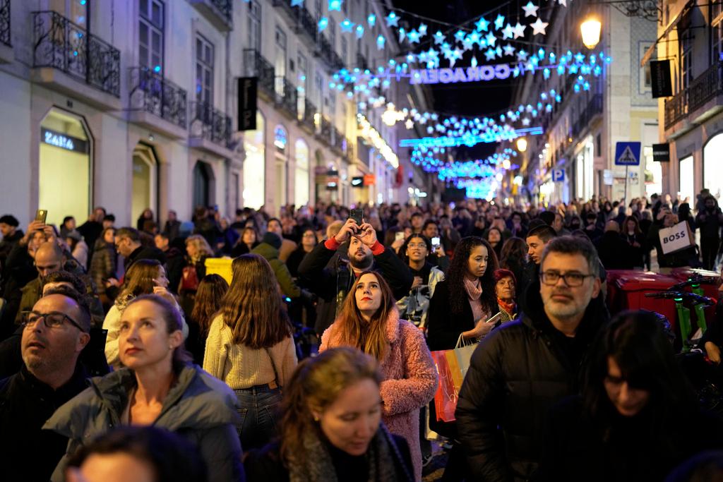 People look up at Christmas lights