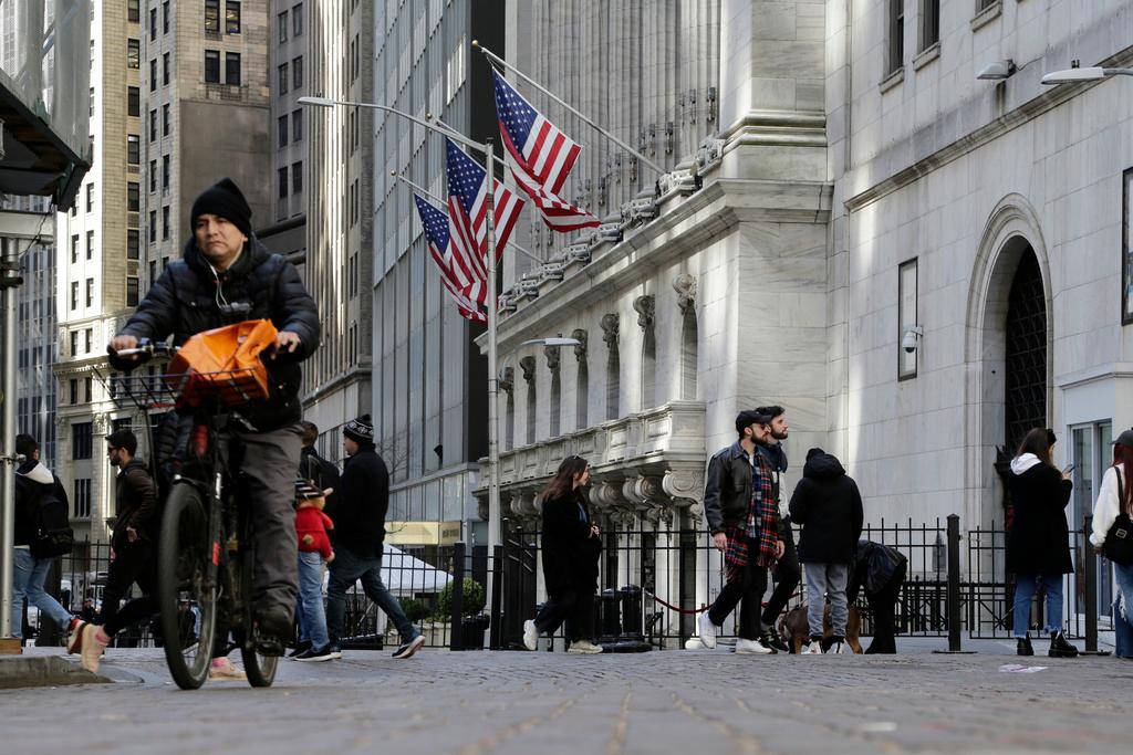 People pass the front of the New York Stock Exchange in New York