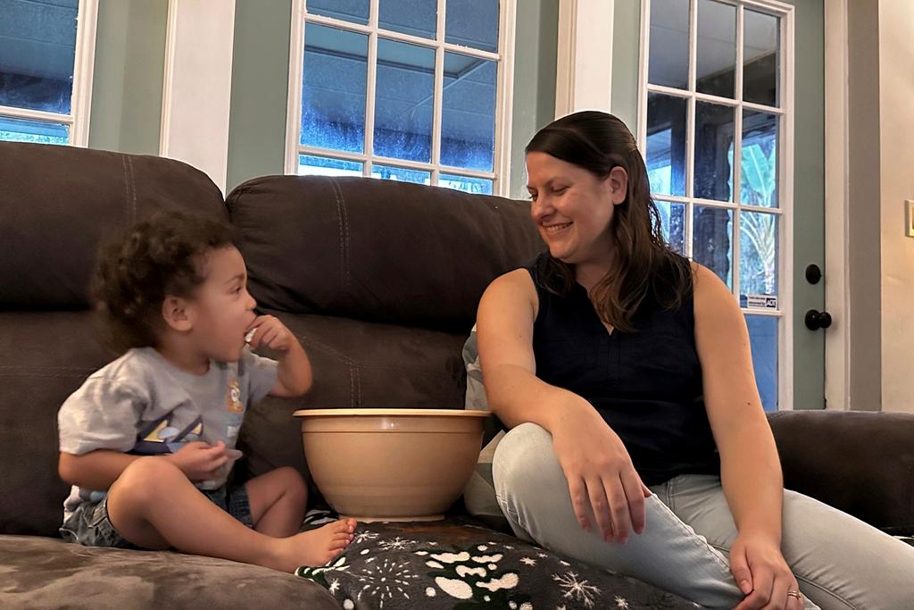 Megan Cherry eats popcorn with her two-year-old son in Temple Terrace, Fla. She is concerned about the ongoing impact of inflation on the grocery budget for her family of six.