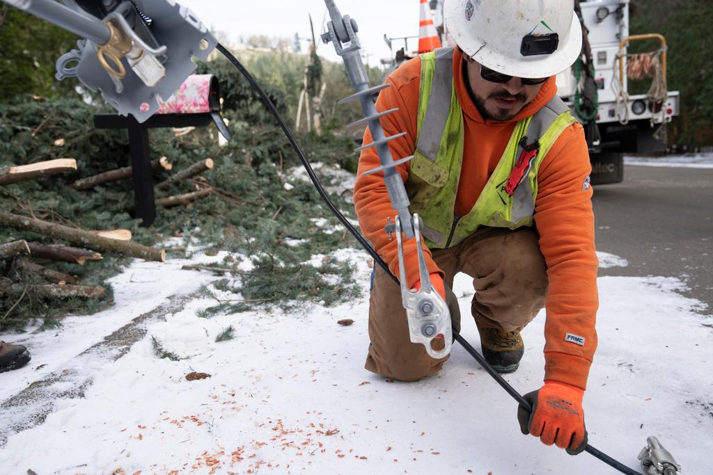 Worker from PG&E works to install a new power line as crews work on restoring power
