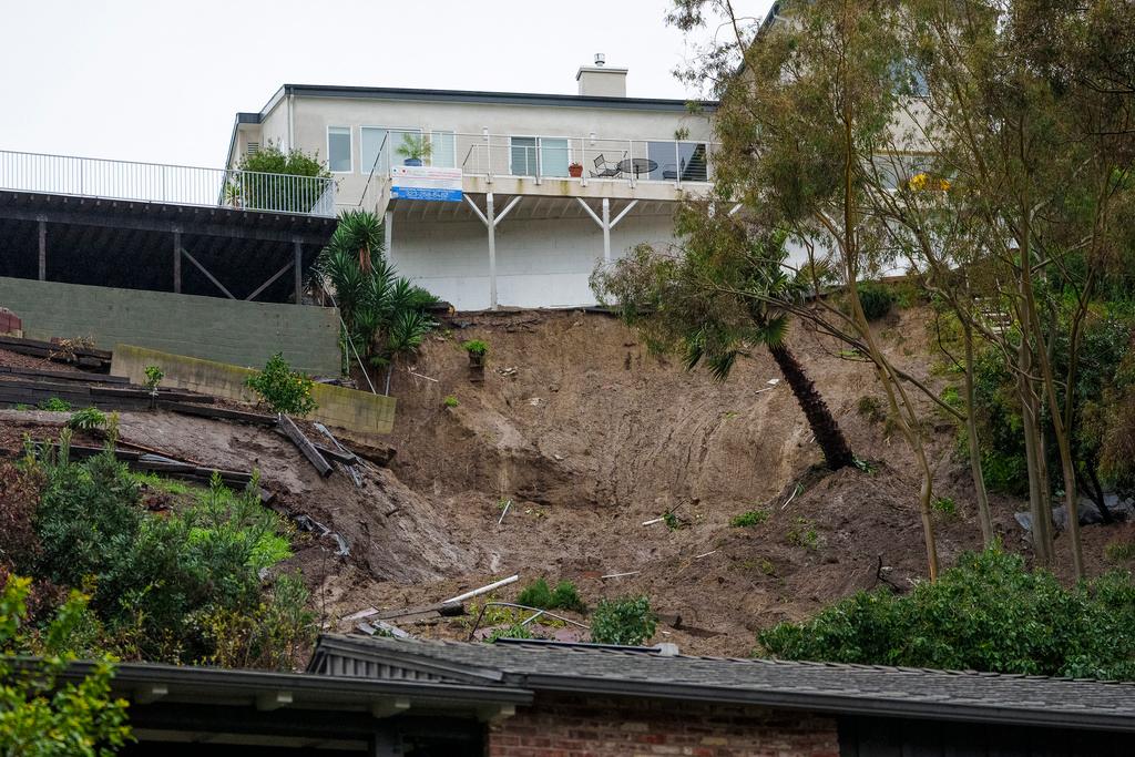 A mudslide scarred hillside in the backyard of a home