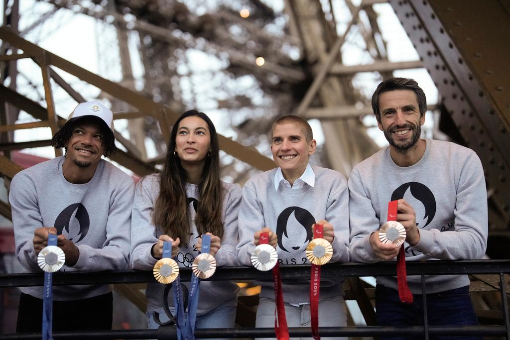 Paris 2024 Olympics Organizing Committee President Tony Estanguet, right, French athletes Marie Patouillet, center right, Sara Balzer, center left, and Arnaud Assoumani, left, present the Paris 2024 Olympic and Paralympic medals at the Eiffel Tower, in Paris