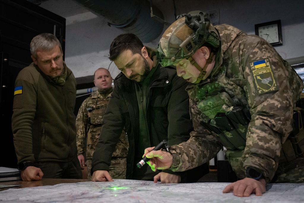 Ukrainian President Volodymyr Zelenskyy, Commander of Ukraine's Ground Forces Col.-Gen. Oleksandr Syrsky, right, look at a map during their visit to the front line city of Kupiansk, Kharkiv region