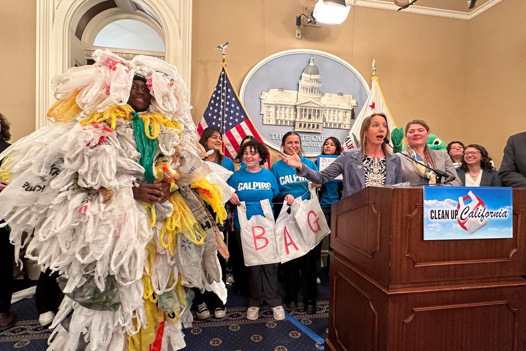 California Democratic state Sen. Catherine Blakespear gestures toward a person covered in plastic bags during a news conference at the Capitol in Sacramento, Calif.