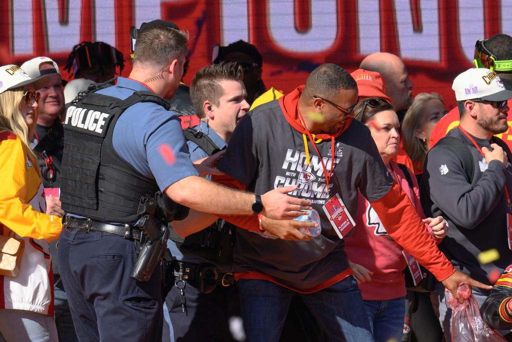Police clear the Kansas City Chiefs from the stage after a shooting at their Super Bowl victory rally 