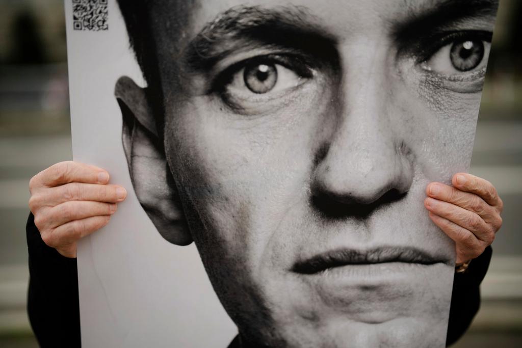A man holds a poster with a portrait of opposition leader Alexei Navalny during a protest in front of the Russian embassy in Berlin, Germany, Friday, Feb. 16, 2024.