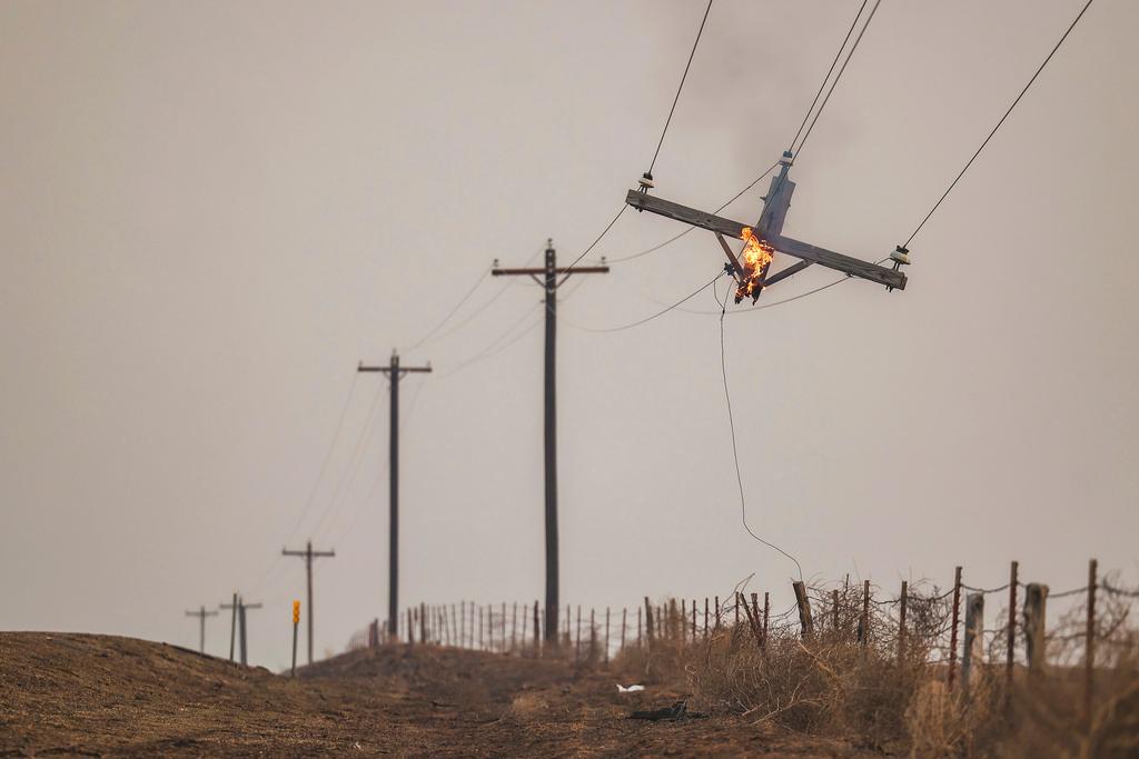 Telephone pole burns from the Smokehouse Creek Fire in Canadian, Texas