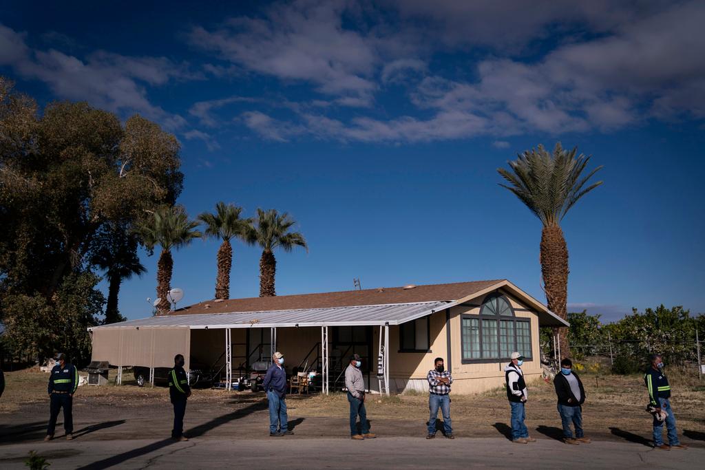 Farm workers wait in line at Tudor Ranch in Mecca, Calif., Jan. 21, 2021. 