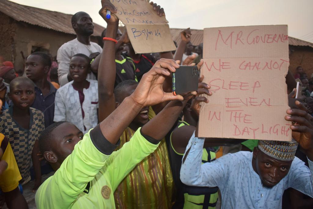 People gather around an area were gunmen kidnapped school children in Chikun, Nigeria