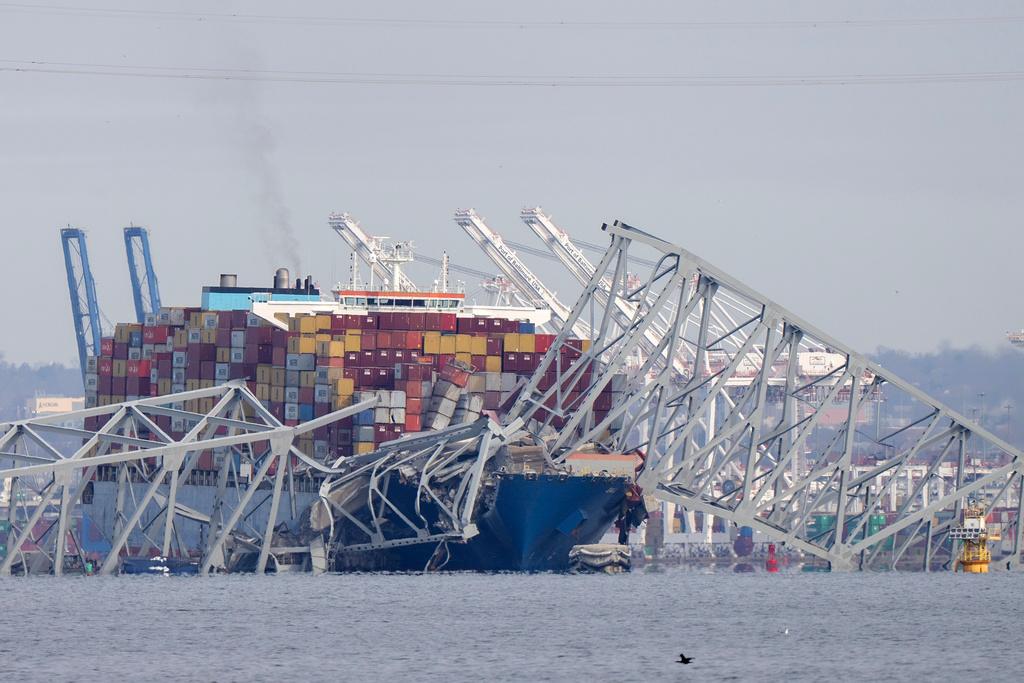 A container ship rests against wreckage of the Francis Scott Key Bridge 