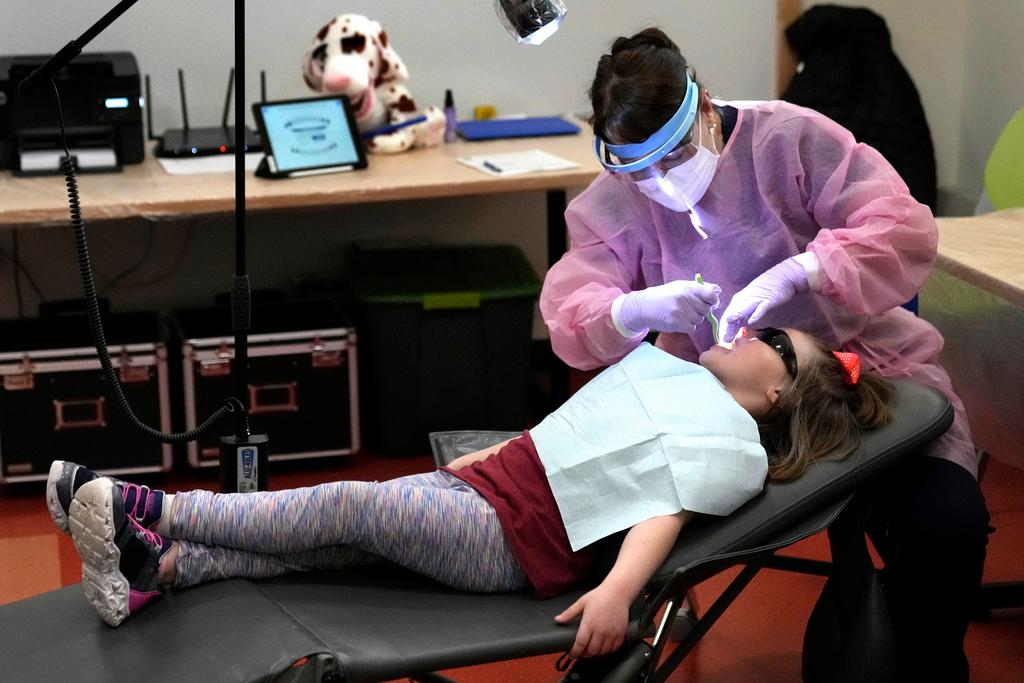 Dental hygienist Mary Davis examines Amber Warner's teeth at the Christa McAuliffe School in Concord, N.H.