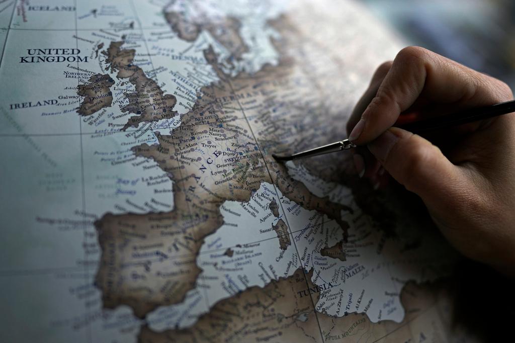 An artist paints a globe at a studio
