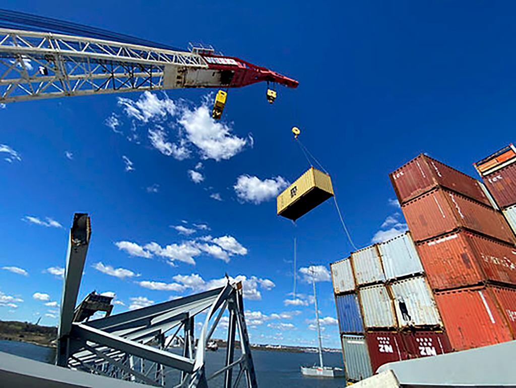 response crews begin removing shipping containers from the deck of the cargo ship Dali using a floating crane barge at the site of the Francis Scott Key Bridge