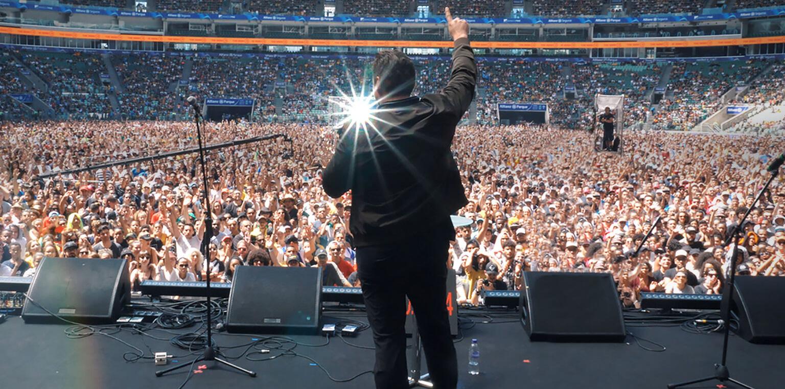 Man on stage in front of thousands of people