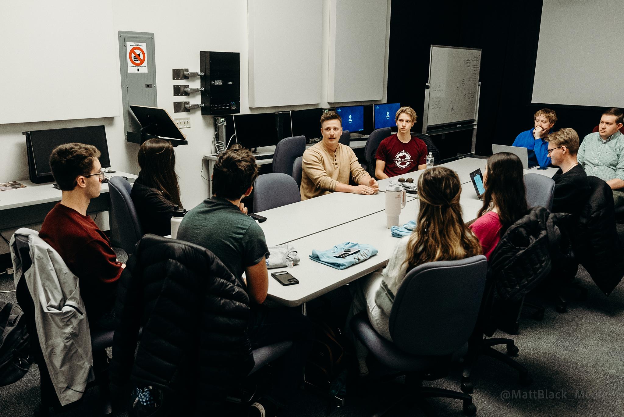 Parker Adams, center, is surrounded by Cedarville University students interested in learning about the movie-making industry.