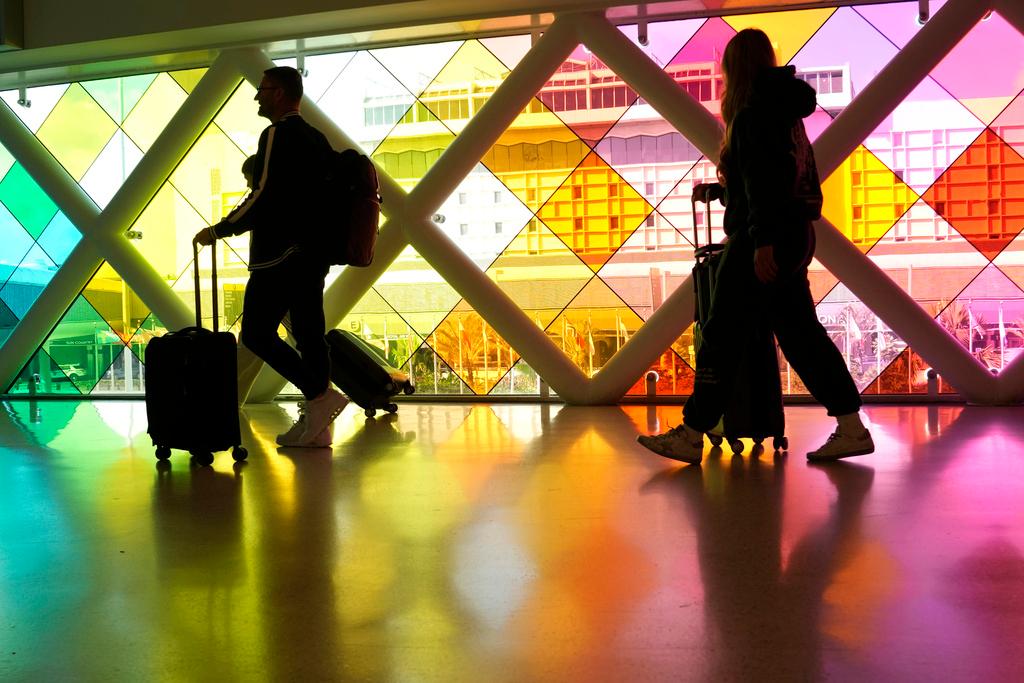 Travelers walk through Miami International Airport on Nov. 22, 2023, in Miami. 