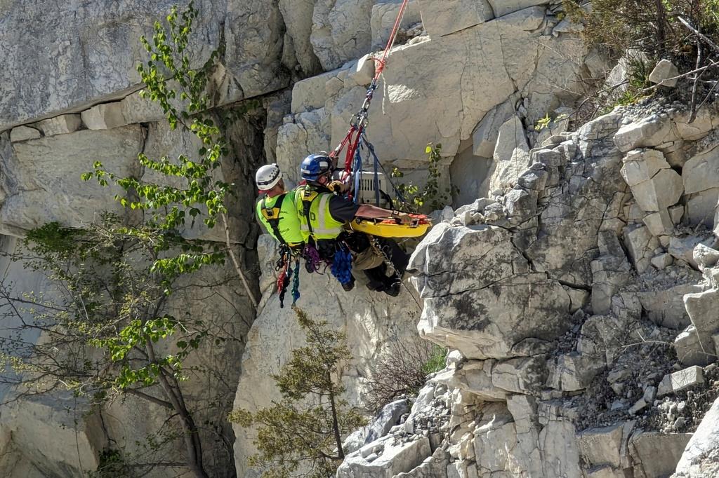 Firefighters rappel down a cliff as they rescuing Rippy, a 30-pound terrier mix dog in North Canaan, CT.