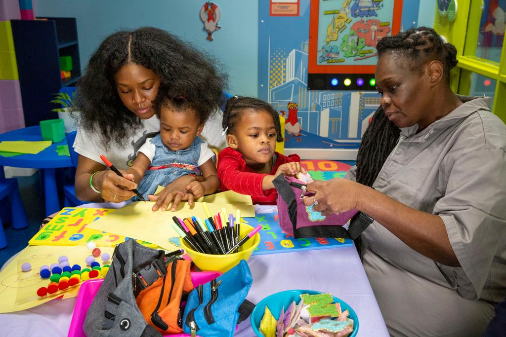 Inmate Nadine Leach, 43, right, visits with her grandchildren and daughter Lashawna Jones, 27, in the newly opened preschool play and learn visitation hub 