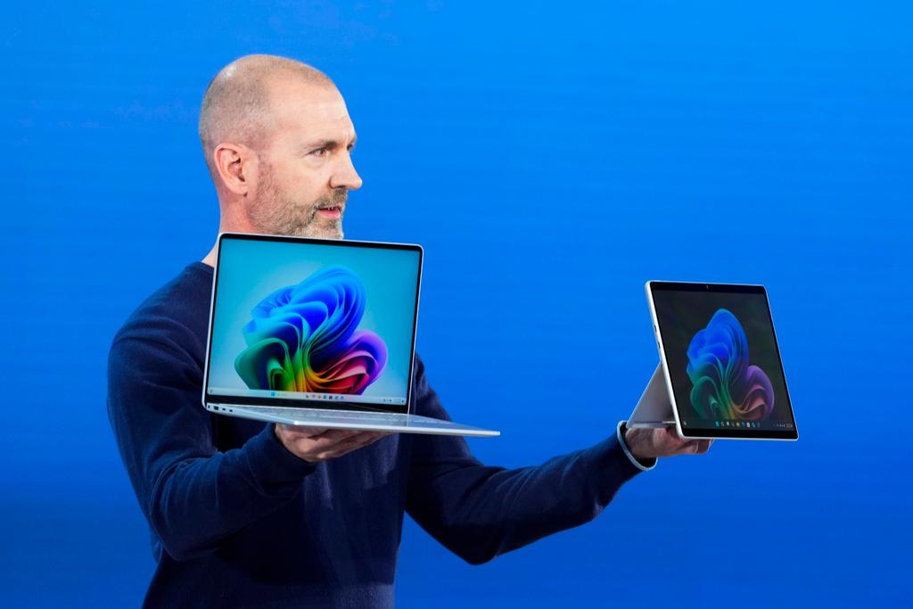 Microsoft's Brett Ostrum holds up new Surface Laptop and Surface Pro