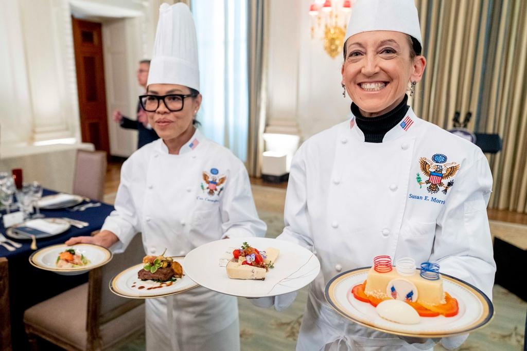 White House executive chef Cris Comerford, left, and White House executive pastry chef Susie Morrison, right, hold dishes