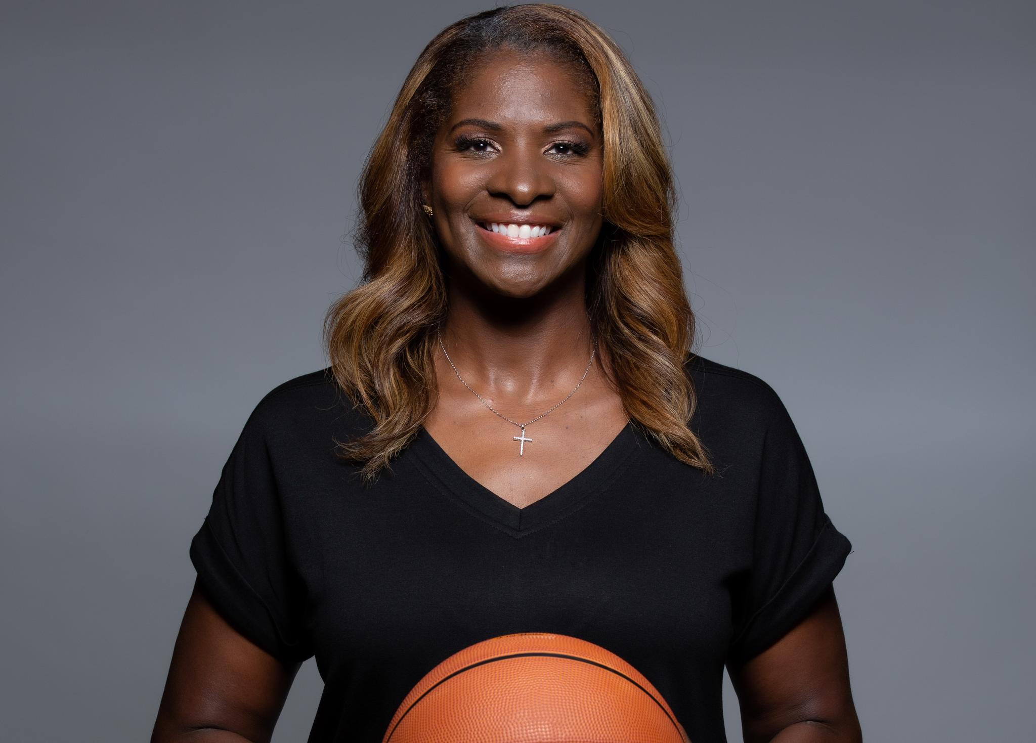 Woman in black shirt, cross necklace, smiling