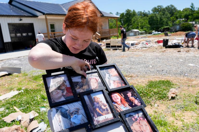 Haley Loukota, looks over family photographs found among storm debris from her demolished home in Madisonville, Ky. 
