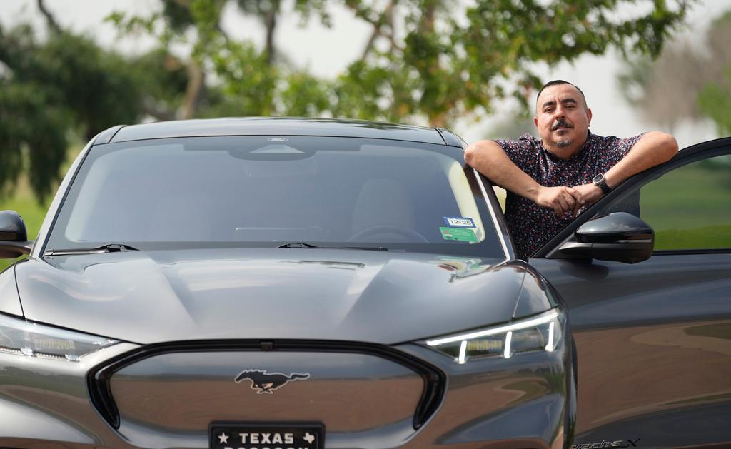 Jose Valdez, 45, who owns three EVs, with his Mustang Mach-E in San Antonio